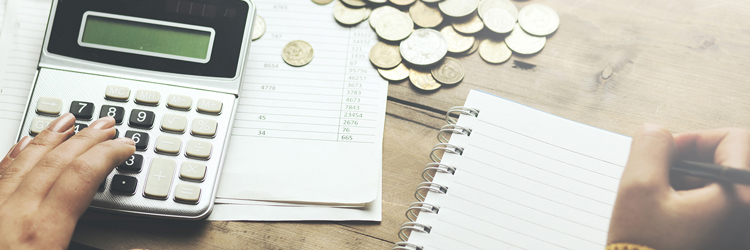 Lommeregner, blok og kuglepen på skrivebord